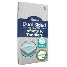 Load image into Gallery viewer, Hiccapop dual-sided crib mattress for infants to toddlers, standing upright with safety certifications from Baby Safety Alliance and CertiPUR-US visible.
