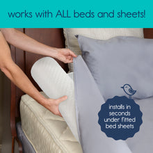 Load image into Gallery viewer, Hands easily sliding the white inflatable bumper under a grey fitted bed sheet. Works with all beds and sheets.
